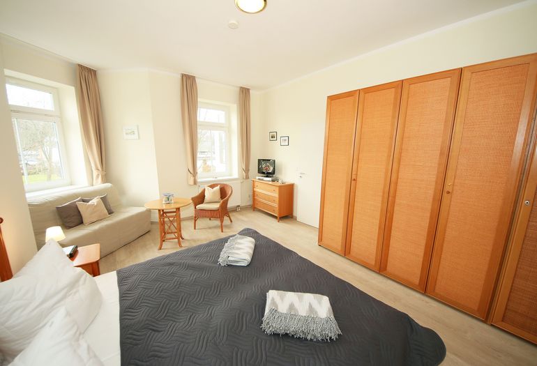 1. Schlafzimmer mit Doppelbett und kleinem Sofa