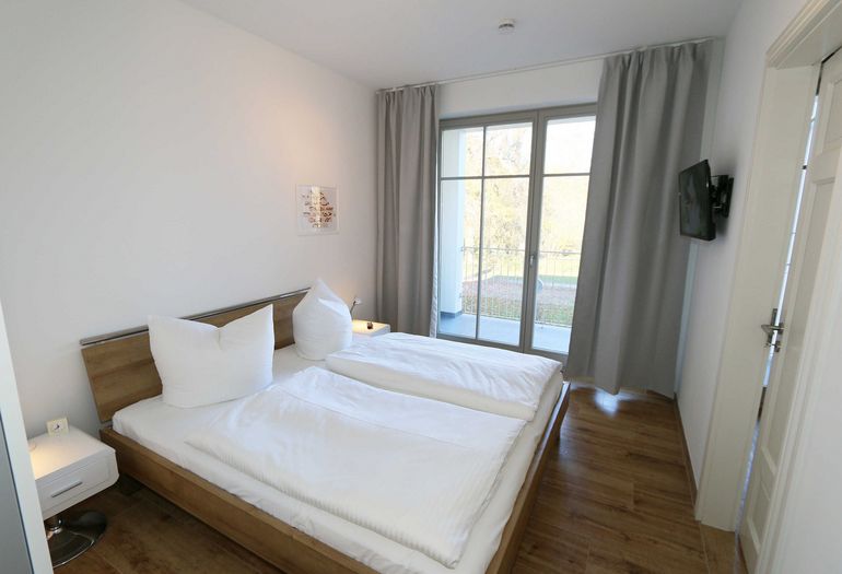 großes Schlafzimmer mit Doppelbett und TV