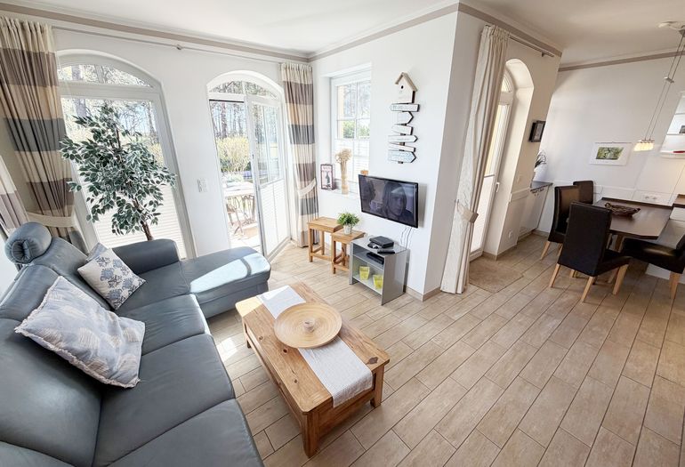 gemütlicher Wohnbereich mit Ecksofa, Glasvitrine und Smart-TV gemütlicher Wohnbereich mit Ecksofa, Glasvitrine und Smart-TV
