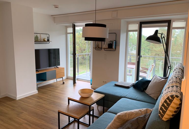 offener Wohnbereich mit Couch, Couchtisch, Stehlampe, Sideboard, Smart-TV mit Netflix Zugang, DVD-Player und Musikanlage offener Wohnbereich mit Couch, Couchtisch, Stehlampe, Sideboard, Smart-TV mit Netflix Zugang, DVD-Player und Musikanlage