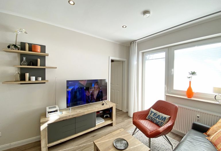Wohnzimmer mit Stuhl und TV