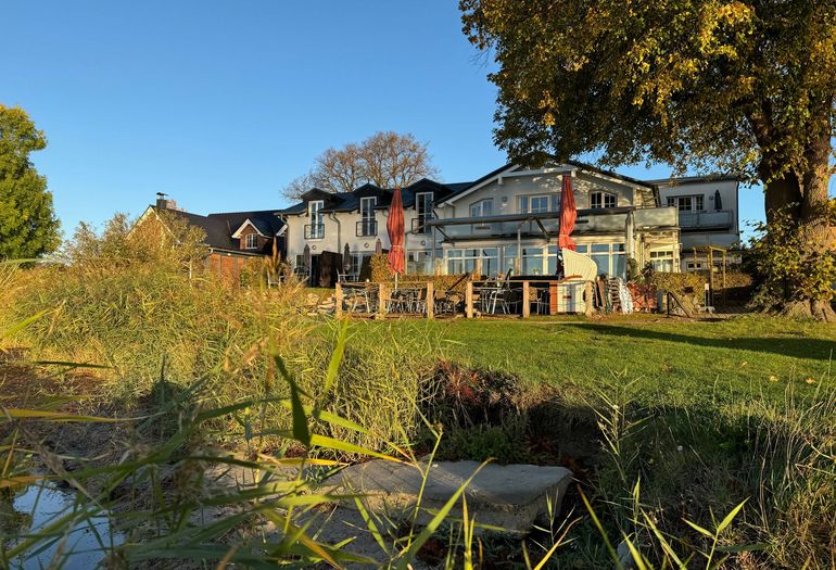 Blick vom Wasser auf das Haus Seeblick mit Restaurant