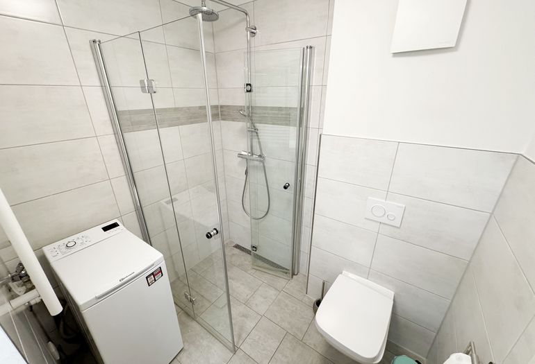 innenliegendes Badezimmer mit ebenerdiger Dusche und WC