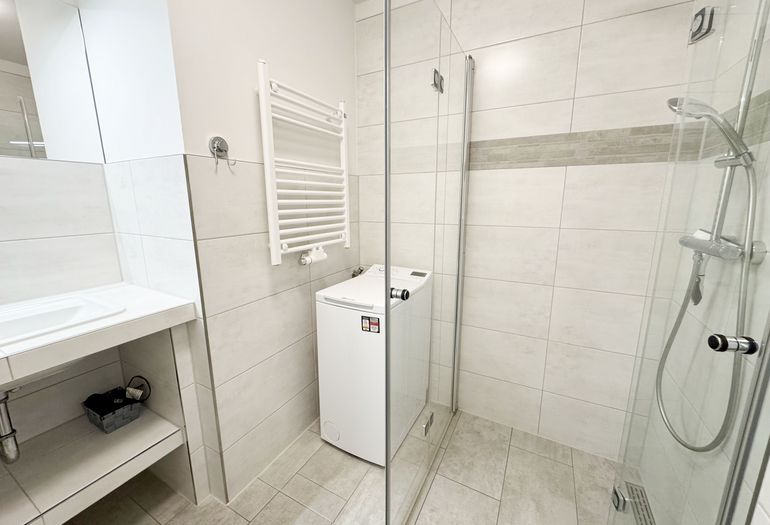 innenliegendes Badezimmer mit ebenerdiger Dusche und Waschmaschine