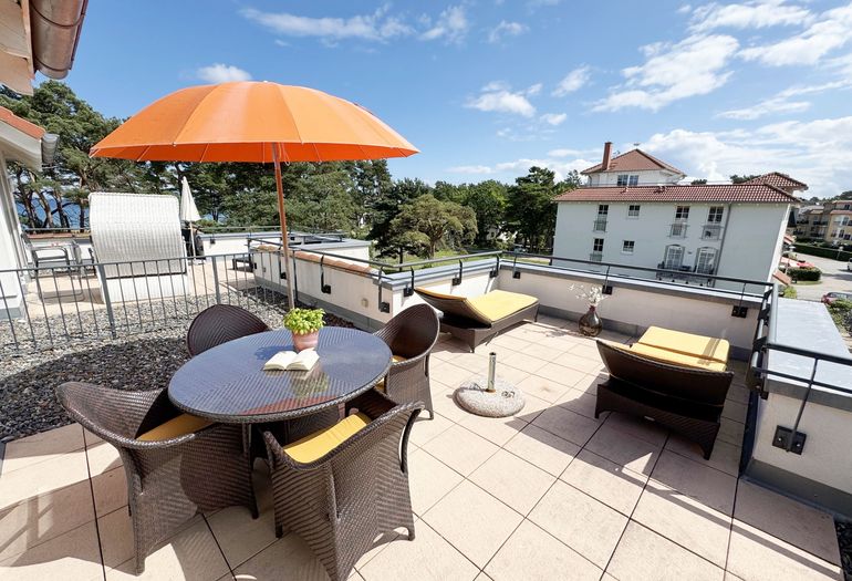 bestuhlte Dachterrasse mit Sonnenliegen