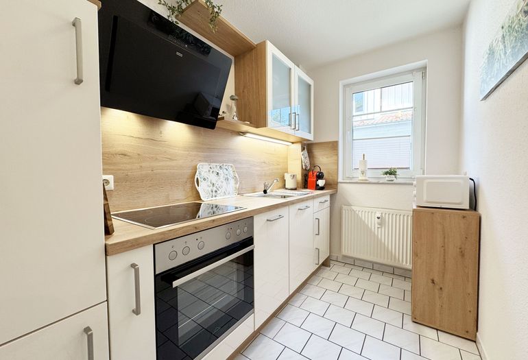 separate Küche mit Cerankochfeld, Backofen und vielen kleinen Helfern