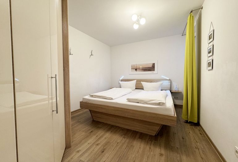 Schlafzimmer mit Doppelbett und Kleiderschrank