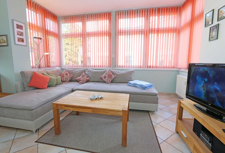 Wohnzimmer mit großer Eckcouch und TV