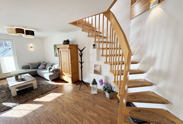 Wohnbereich mit Blick auf die Treppe zum Obergeschoss Wohnbereich mit Blick auf die Treppe zum Obergeschoss