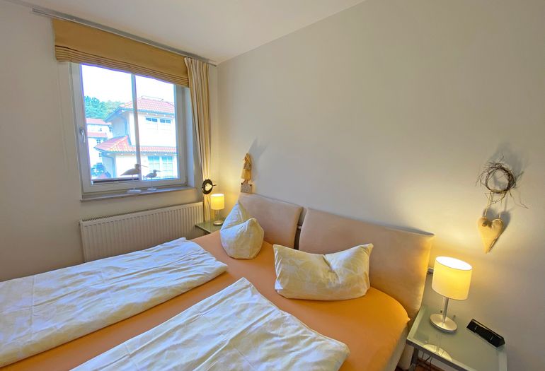 Schlafzimmer mit Fenster und Doppelbett