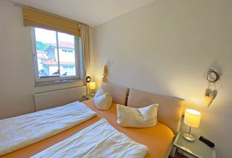 Schlafzimmer mit Fenster und Doppelbett