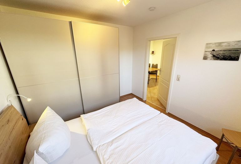 Schlafzimmer mit Doppelbett und Schwebetüren-Kleiderschrank