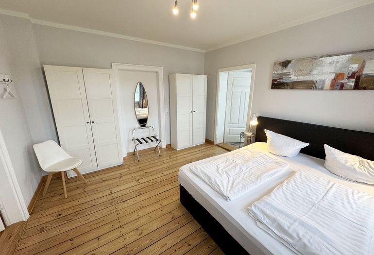 Schlafzimmer mit Doppelbett und Kleiderschrank