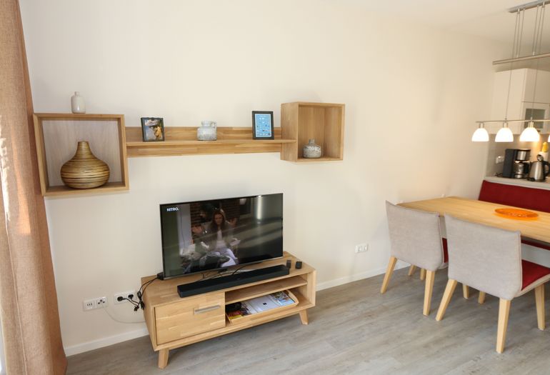 Wohnzimmer mit TV und Esstisch