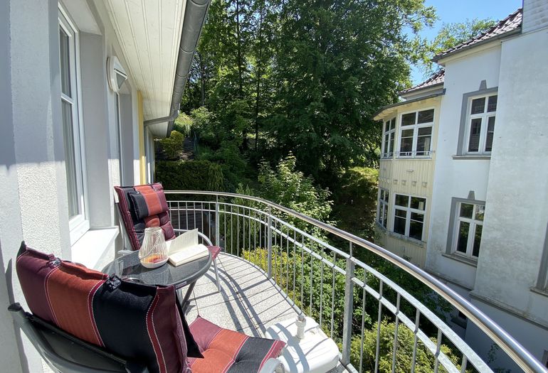 bestuhlter Balkon mit etwas Blick ins Grüne