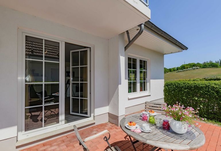 bestuhlte Terrasse durch eine Hecke geschützt