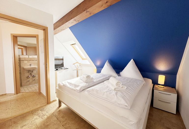 Schlafzimmer mit Doppelbett und Smart-TV