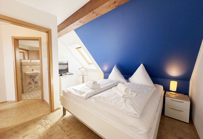 Schlafzimmer mit Doppelbett und Smart-TV