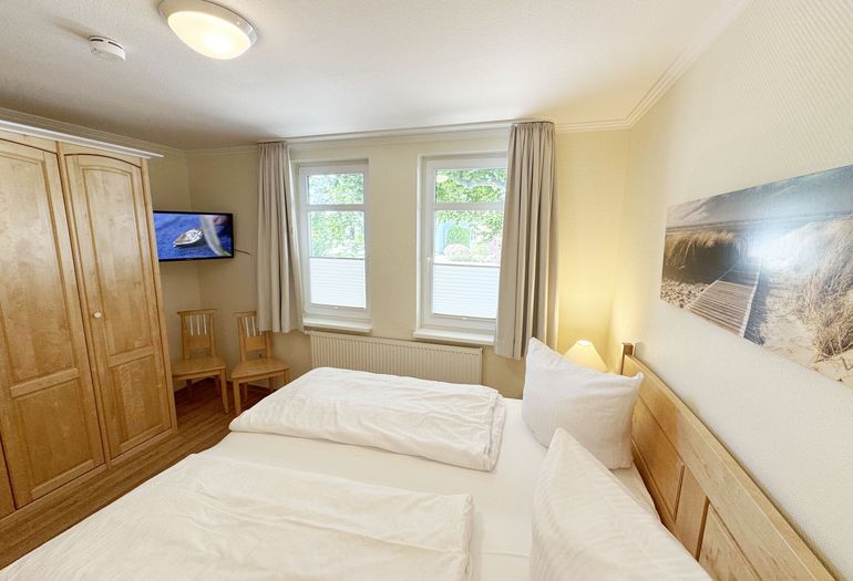 1. Schlafzimmer mit Doppelbett und Kleiderschrank sowie TV 1. Schlafzimmer mit Doppelbett und Kleiderschrank sowie TV