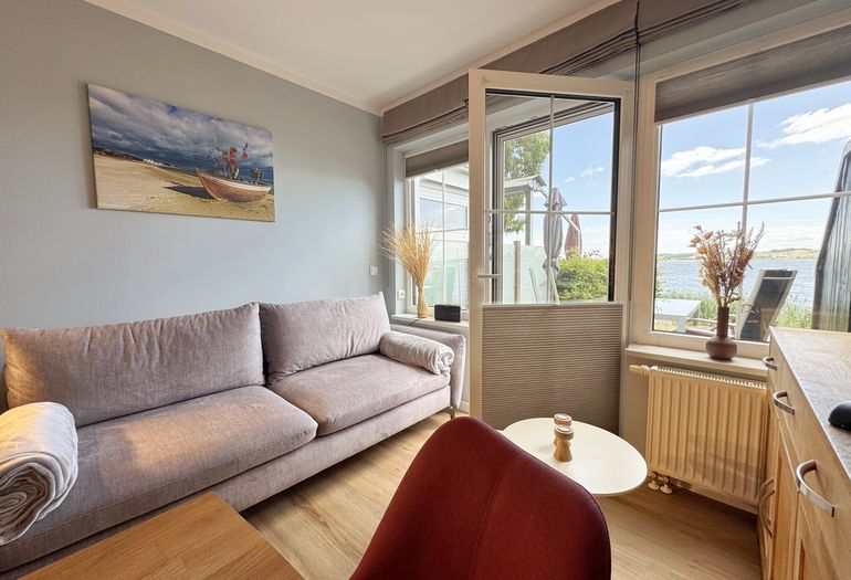 Wohnzimmer mit gemütlicher Couch und Seeblick