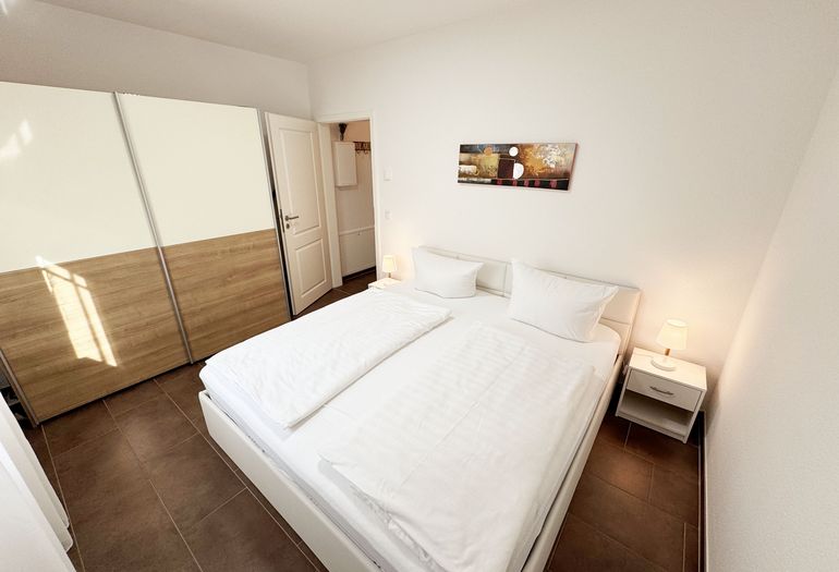 Schlafzimmer mit Doppelbett und Kleiderschrank