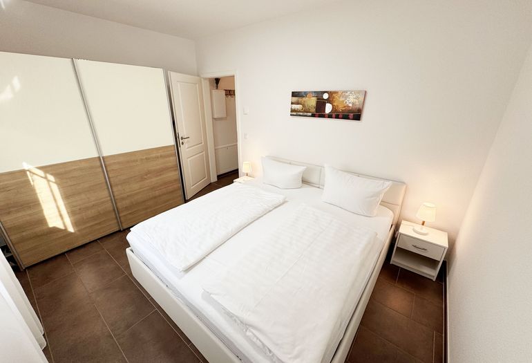 Schlafzimmer mit Doppelbett und Kleiderschrank Schlafzimmer mit Doppelbett und Kleiderschrank