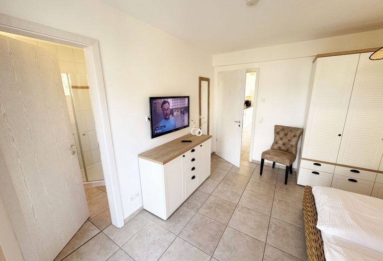 1.Schlafzimmer mit Doppelbett und Kleiderschrank sowie Smart-TV