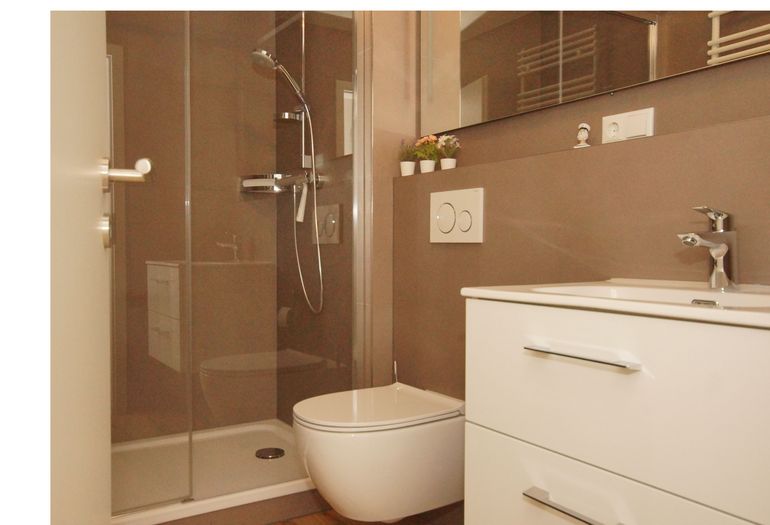 Badezimmer mit Dusche, Waschbecken und WC