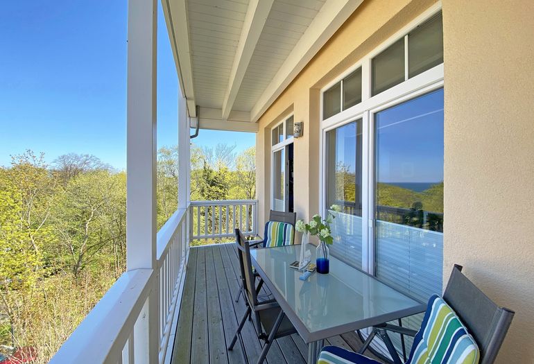 bestuhlter Balkon mit seitlichem Blick Richtung Wald