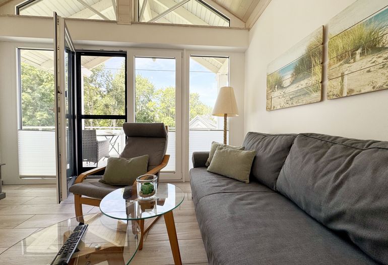 gemütliches Wohnzimmer mit Couch mit Blick auf den Balkon