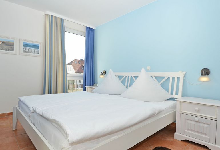 Schlafzimmer mit Doppelbett und Nachttischablagen