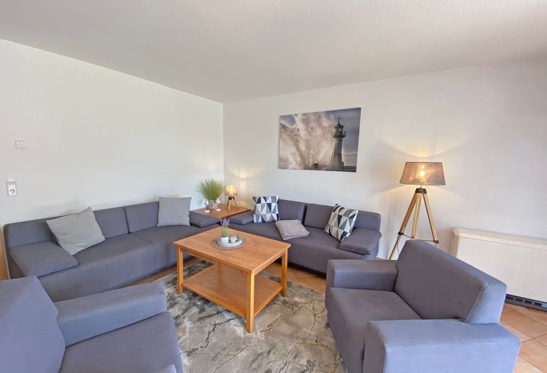 Wohnzimmer mit gemütlicher Couch lädt zum Entspannen ein Wohnzimmer mit gemütlicher Couch lädt zum Entspannen ein