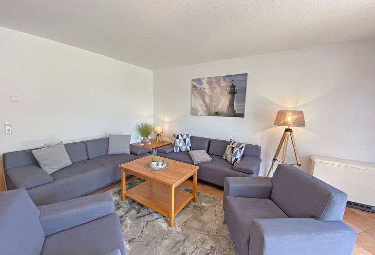 Wohnzimmer mit gemütlicher Couch lädt zum Entspannen ein Wohnzimmer mit gemütlicher Couch lädt zum Entspannen ein