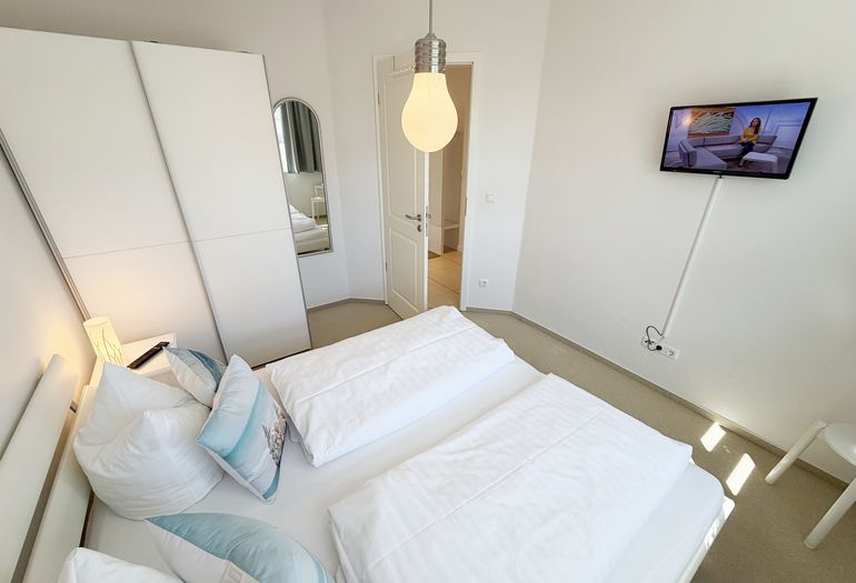 Schlafzimmer mit Doppelbett und Smart-TV Schlafzimmer mit Doppelbett und Smart-TV