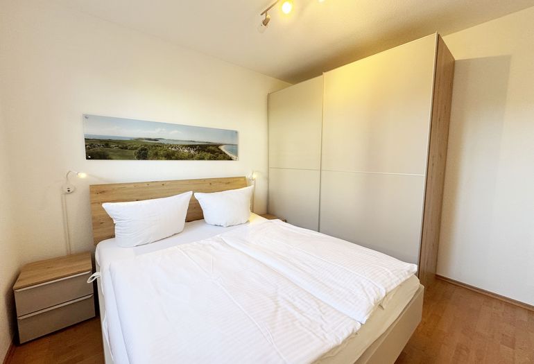 Schlafzimmer mit Doppelbett und Nachttischablagen