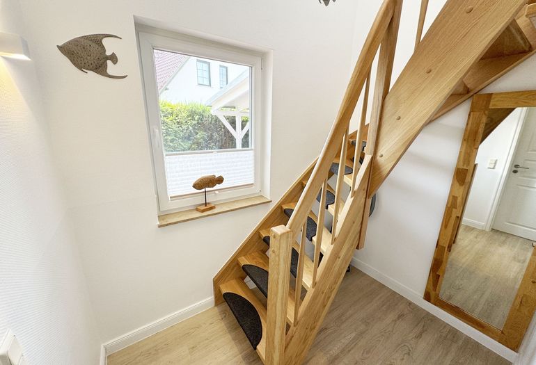 Flur mit etwas steiler Holztreppe in das Obergeschoss