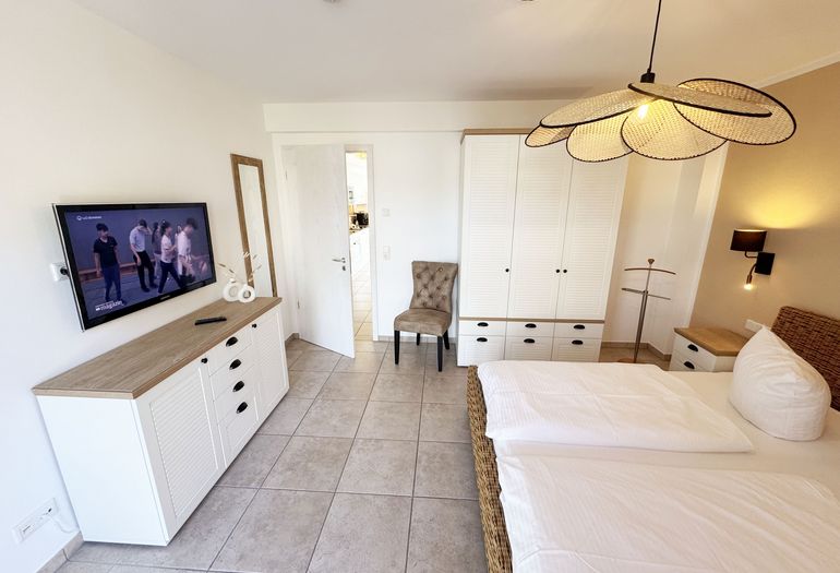 1.Schlafzimmer mit Doppelbett und Kleiderschrank sowie Smart-TV