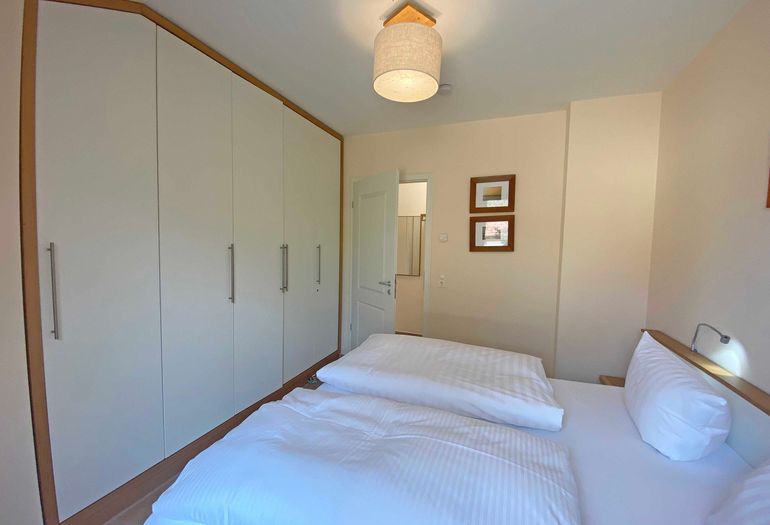 Schlafzimmer mit Doppelbett und Kleiderschrank