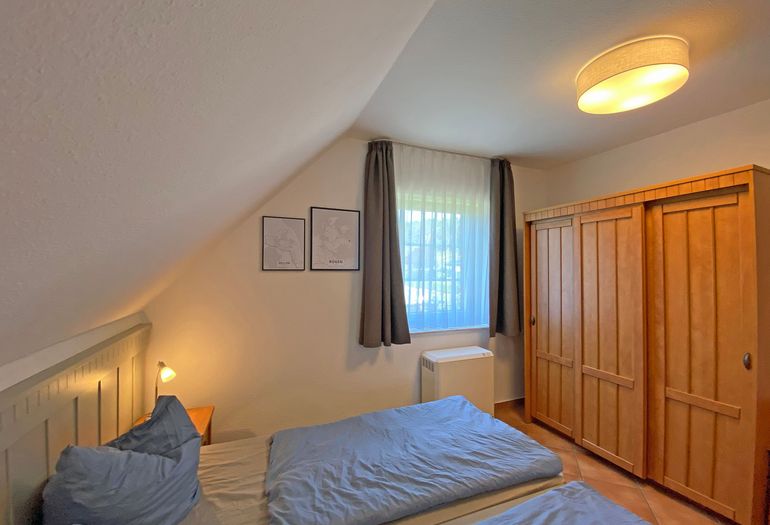 Schlafzimmer mit Doppelbett und Kleiderschrank