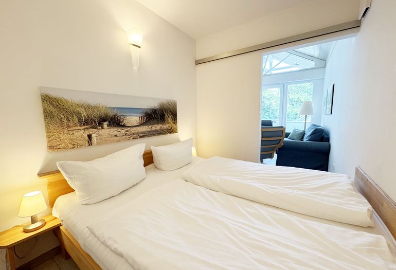 Schlafzimmer mit Doppelbett und Nachttischablagen