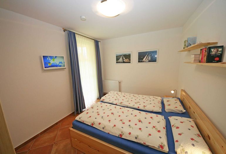 Schlafzimmer mit Doppelbett und TV