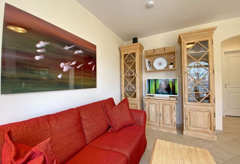 Wohnzimmer mit gemütlicher Couch und TV